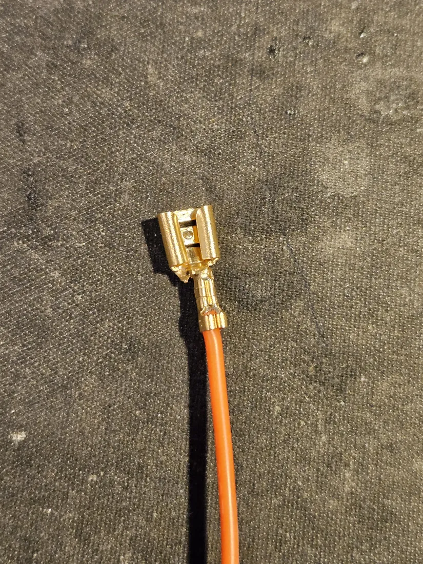 An orange pack lead wire with a gold female spade crimp terminal on the end