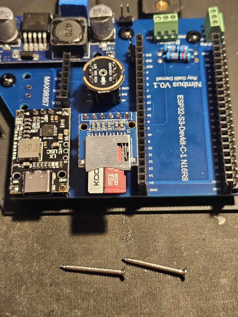 Assembled Nimbus shield on the ESP32-S3 DevKit with the microSD holder, and two longer screws laid on the bench below